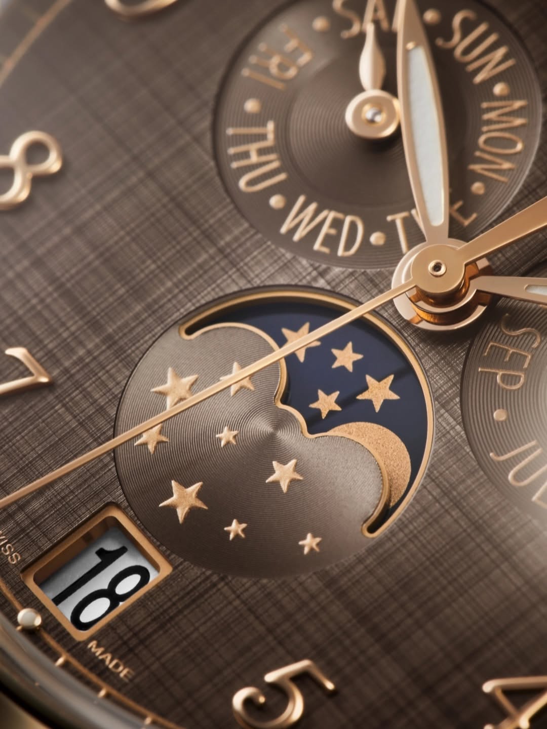 Close-up of a golden dial with moon phase and day indication